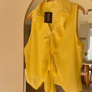 Inicio blusa amarilla sin mangas con volantes y lazo – elsa